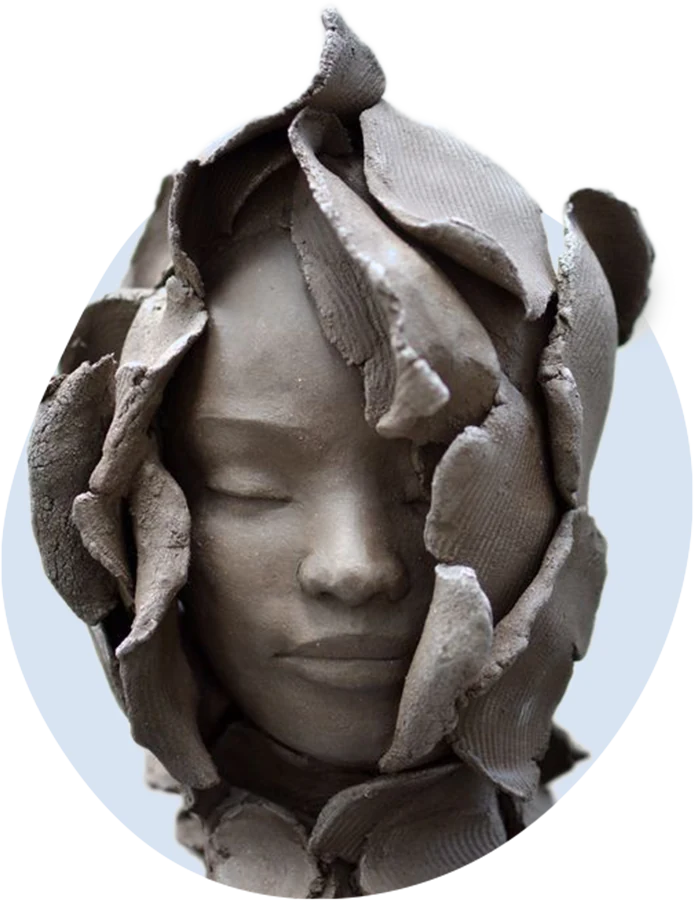 Clay sculpture of a woman’s face with her eyes closed, wrapped in layers of curling clay leaves